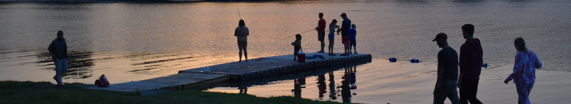 People fishing off dock at dusk in South Frontenac