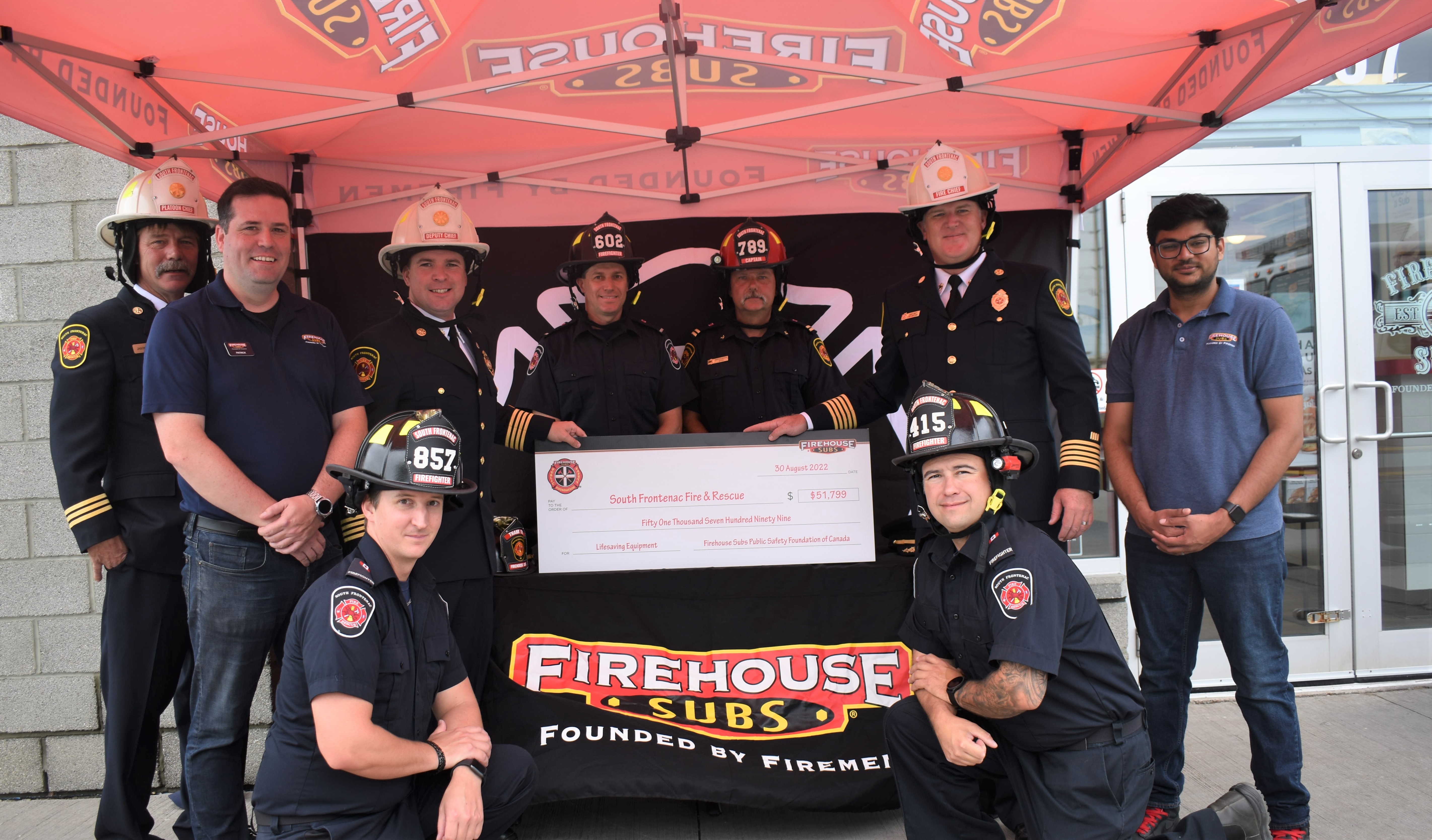 South Frontenac Fire and Rescue crew receives cheque from Firehouse Subs