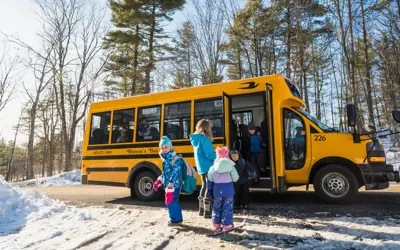 Kids getting on a school bus